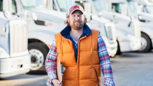 Man standing in front of semi-truck fleet