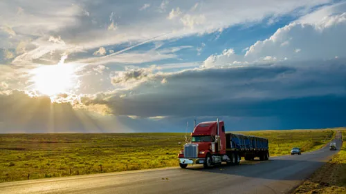 American style truck on freeway pulling load